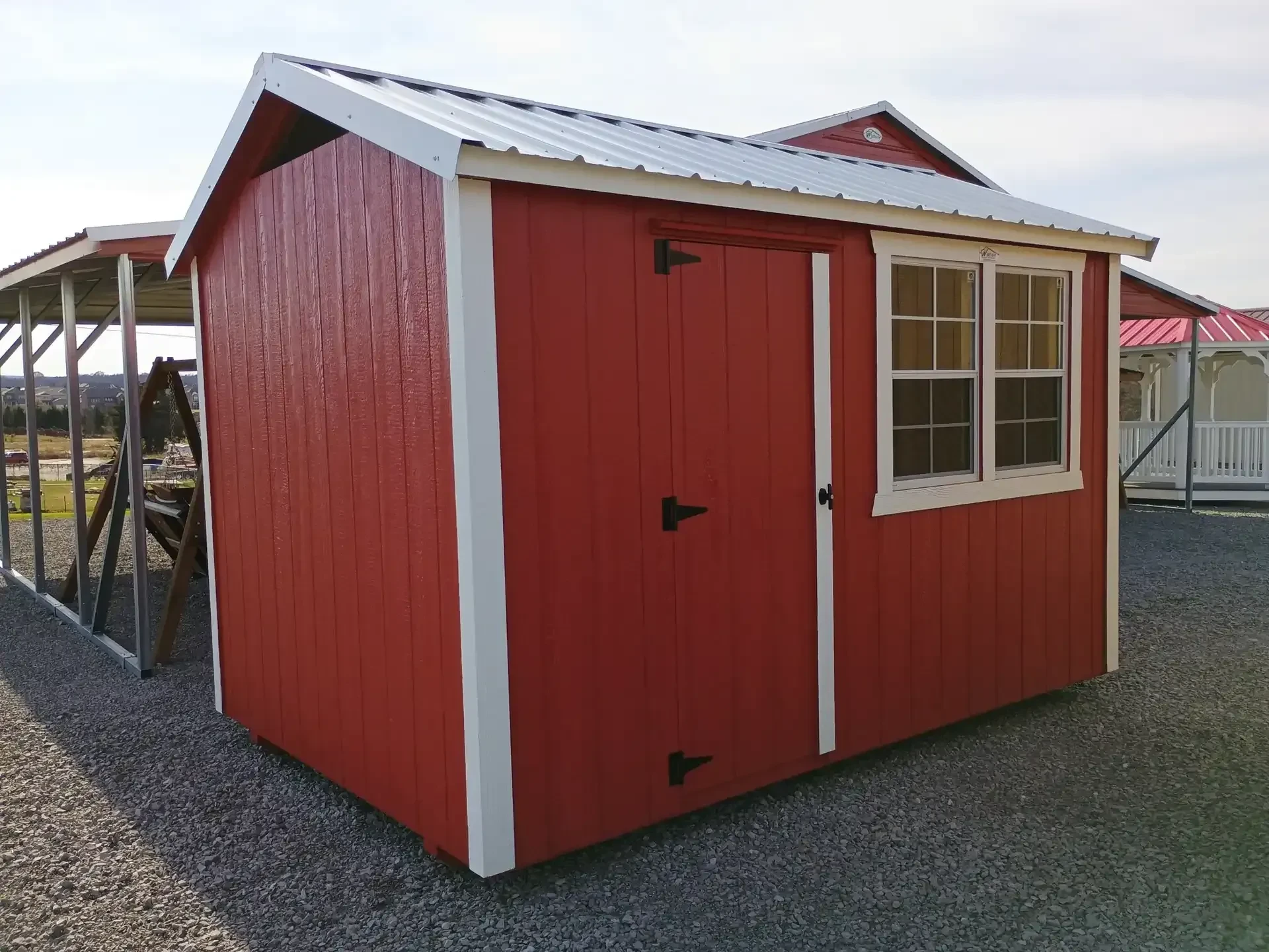 a red chicken coop with white trim and two windows and a single barn door to walk in