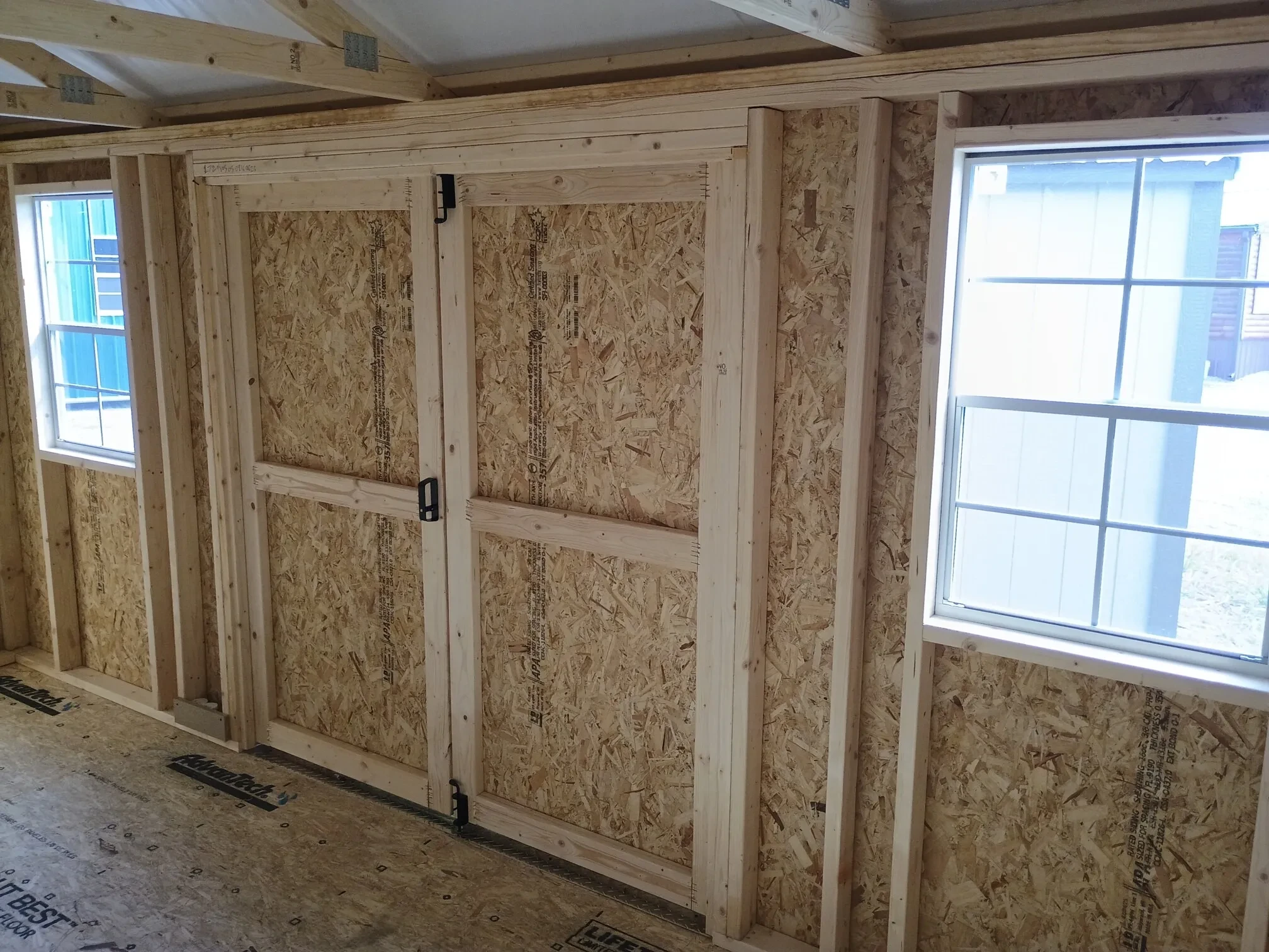 the inside of a wood garden shed showing the double doors closed