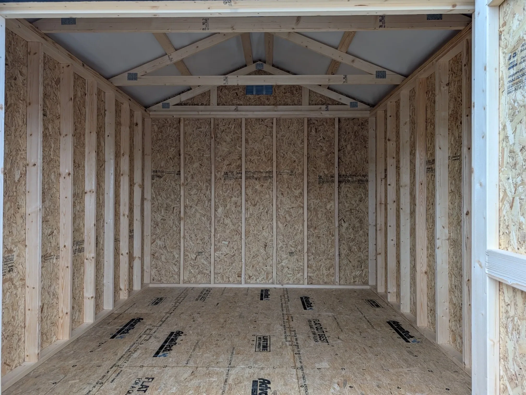 inside a wood shed showing the door open and the floors