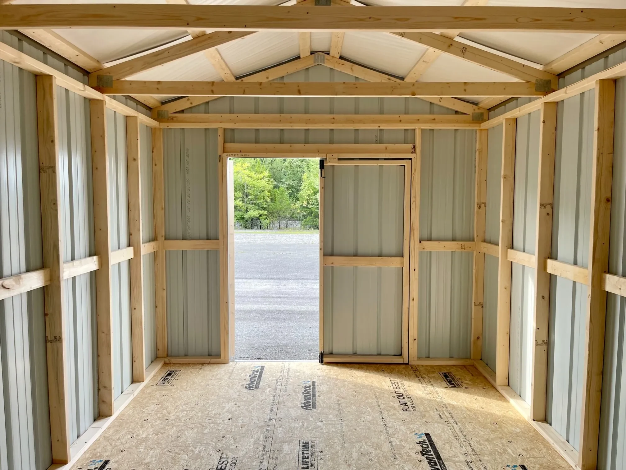 looking through double doors that are open from inside a metal shed