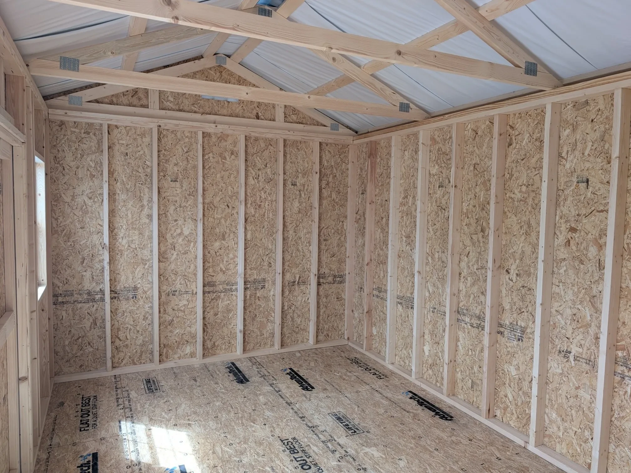 inside a wood garden shed showing the insulation under the roof