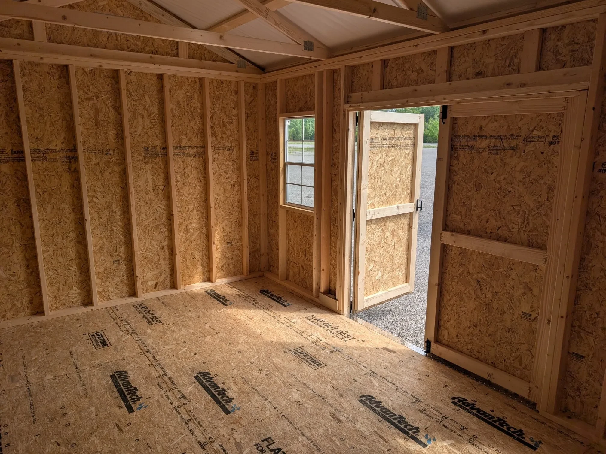 inside a wood garden shed showing the double doors that are open