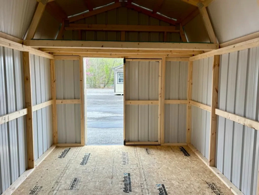 inside a metal lofted barn looking through the double doors which are open and a loft above them