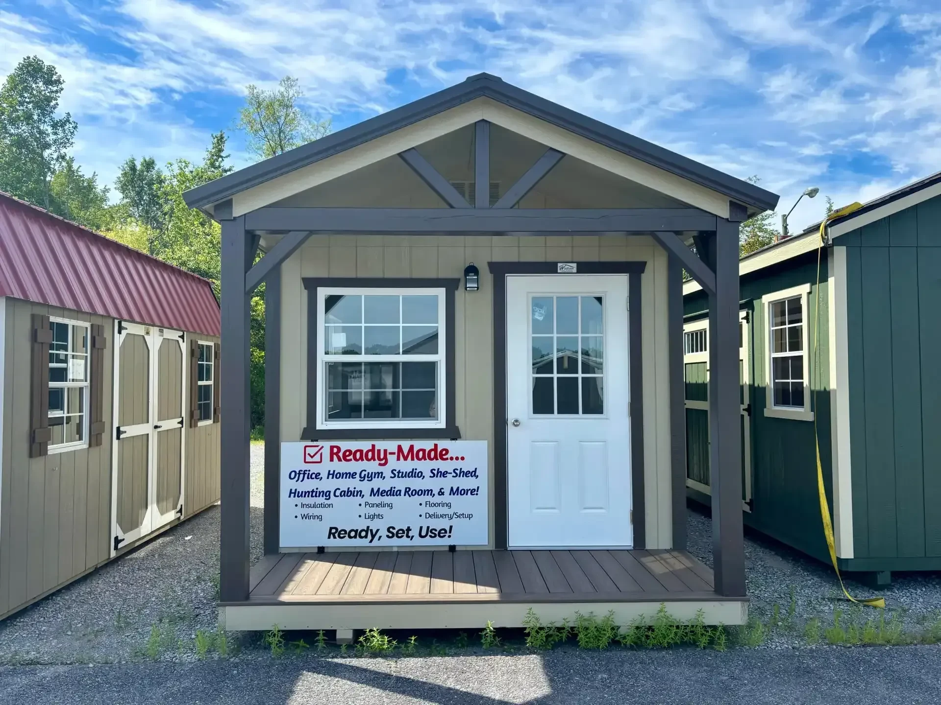 the front of a cabin with a porch and a walk-in door and an insulated window