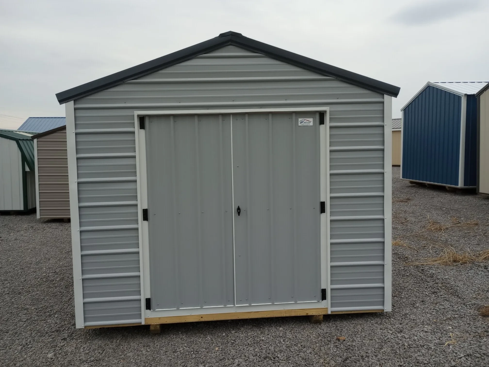 a gray metal utility shed with double doors