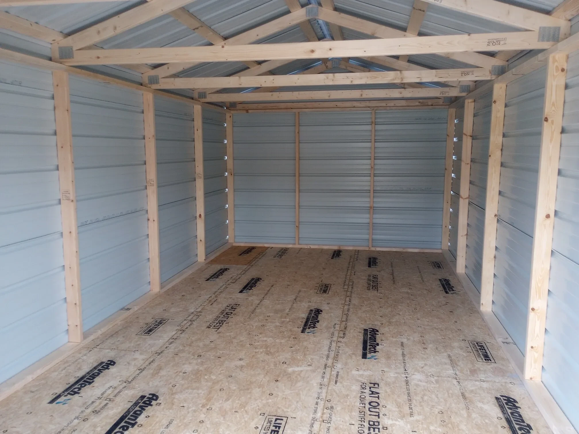 inside a gray metal utility shed showing the floor and framing