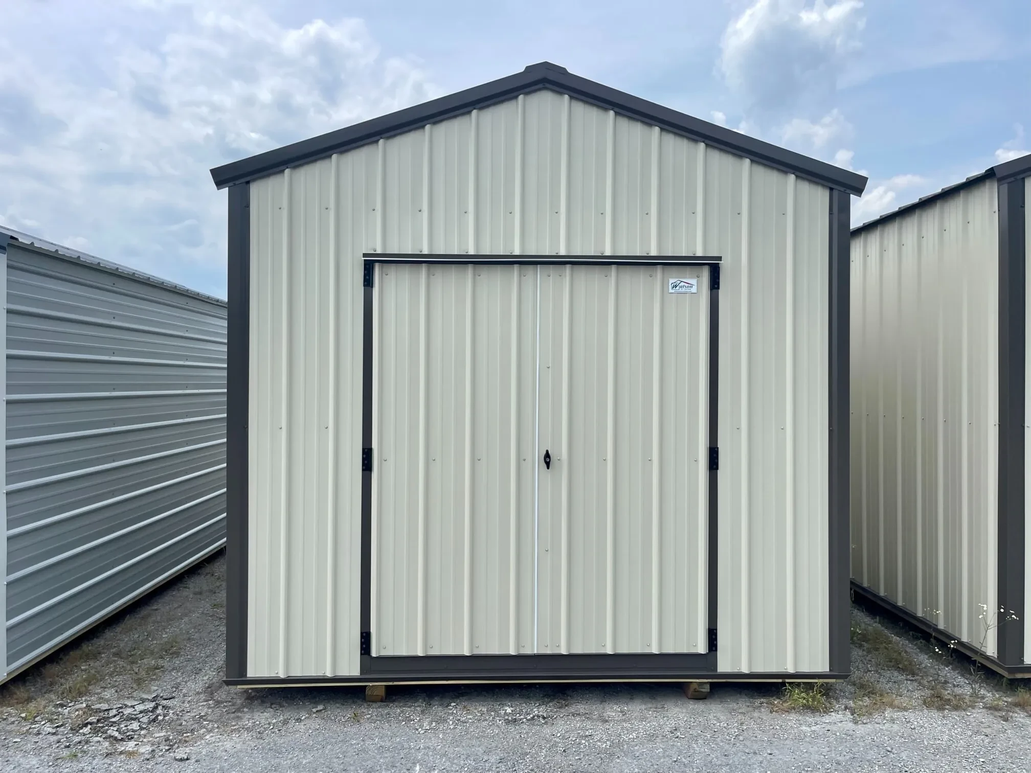 a metal utility shed colored bronze with double doors