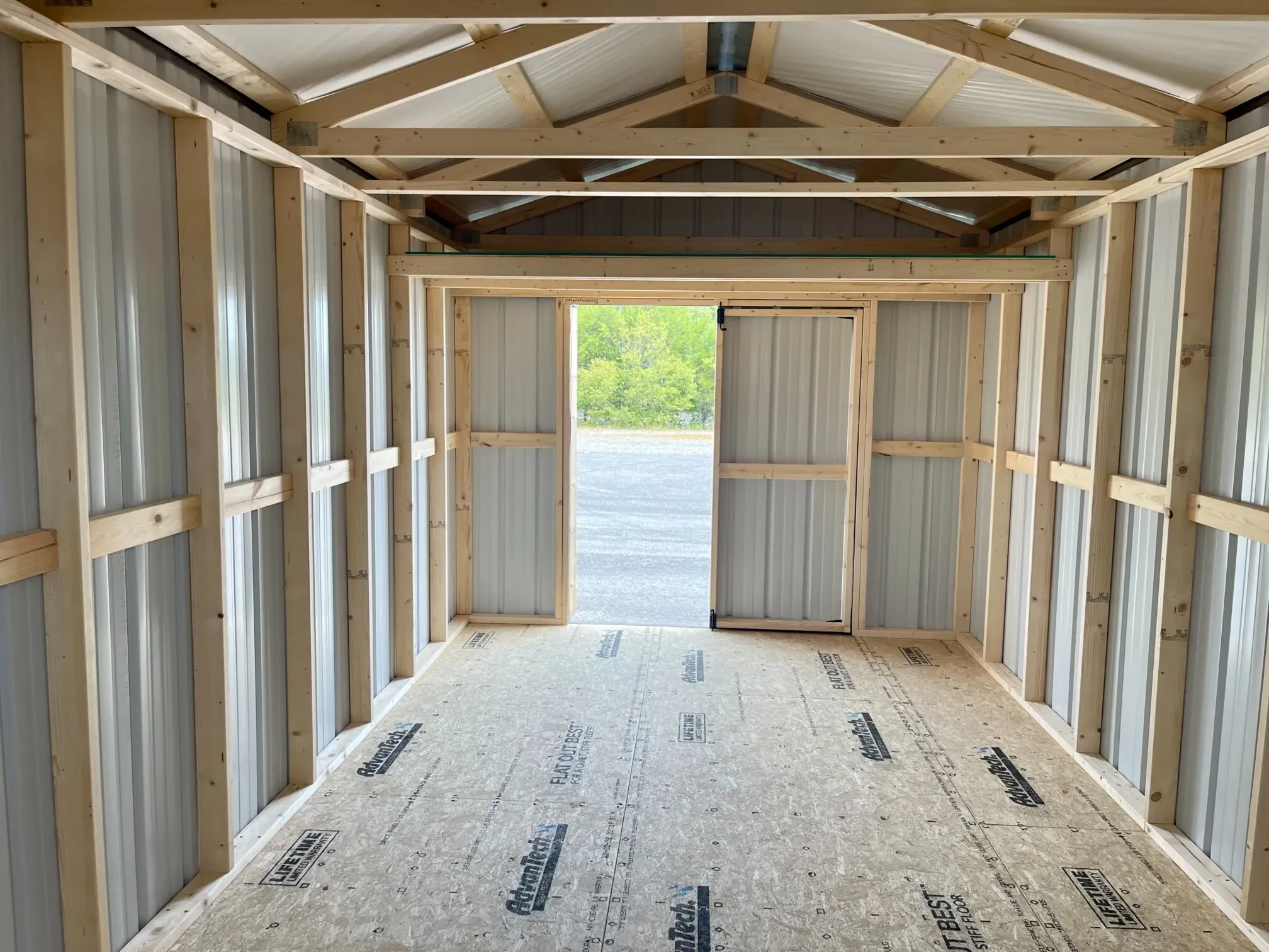 inside a metal shed looking through the double doors that are open