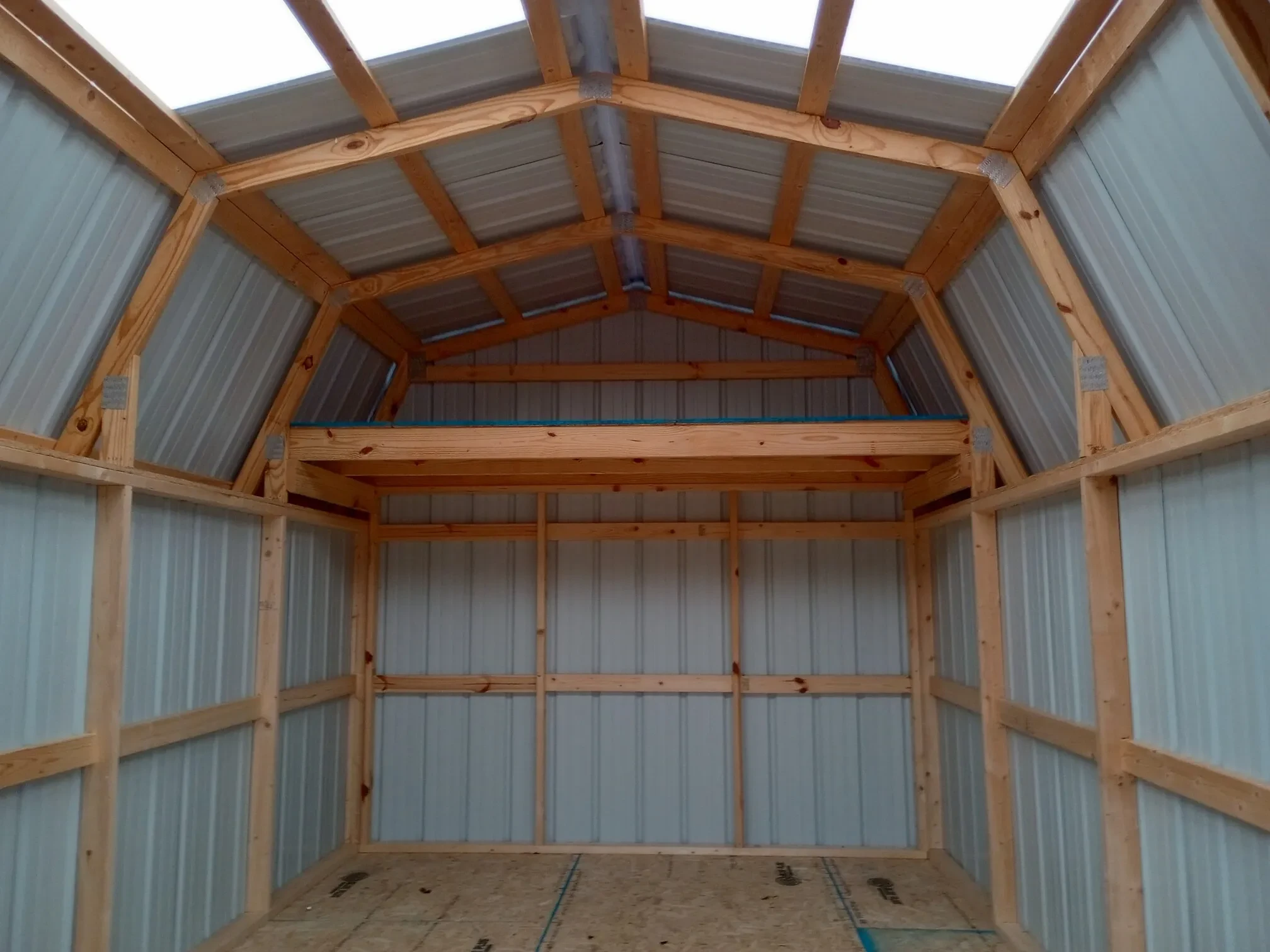 inside a metal lofted shed with a loft along the back wall
