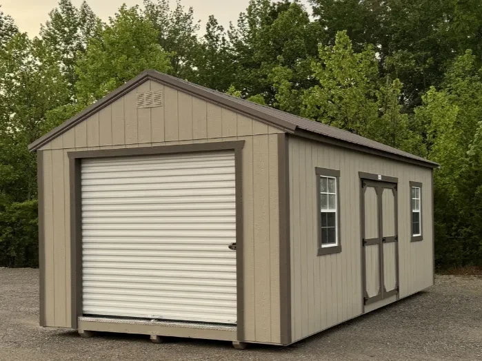 a tan garage shed with a rollup garage door in the end and double doors and two windows in the side
