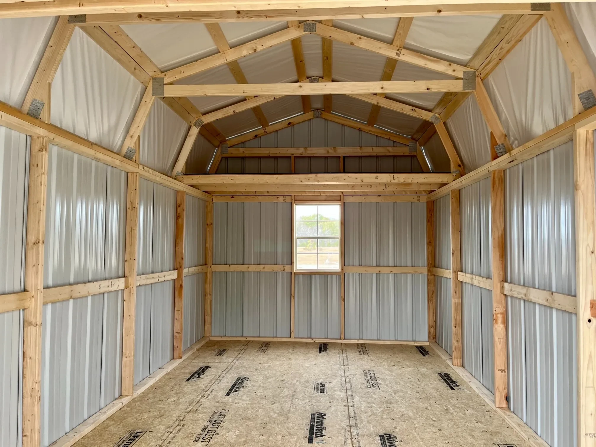 the interior of a metal lofted barn with a loft and a 2x3 window