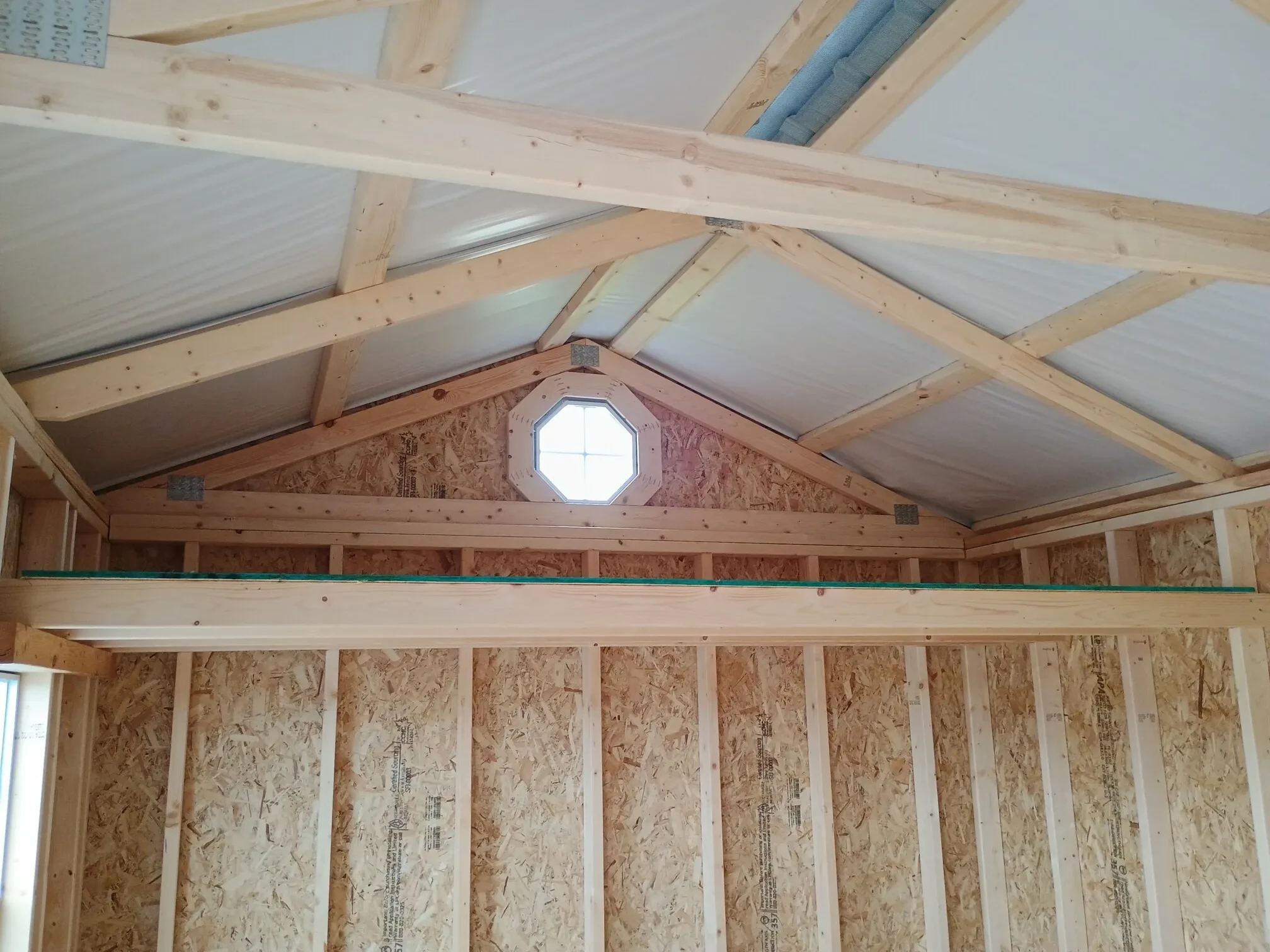 inside a garden shed with an octagon window above the 4' loft