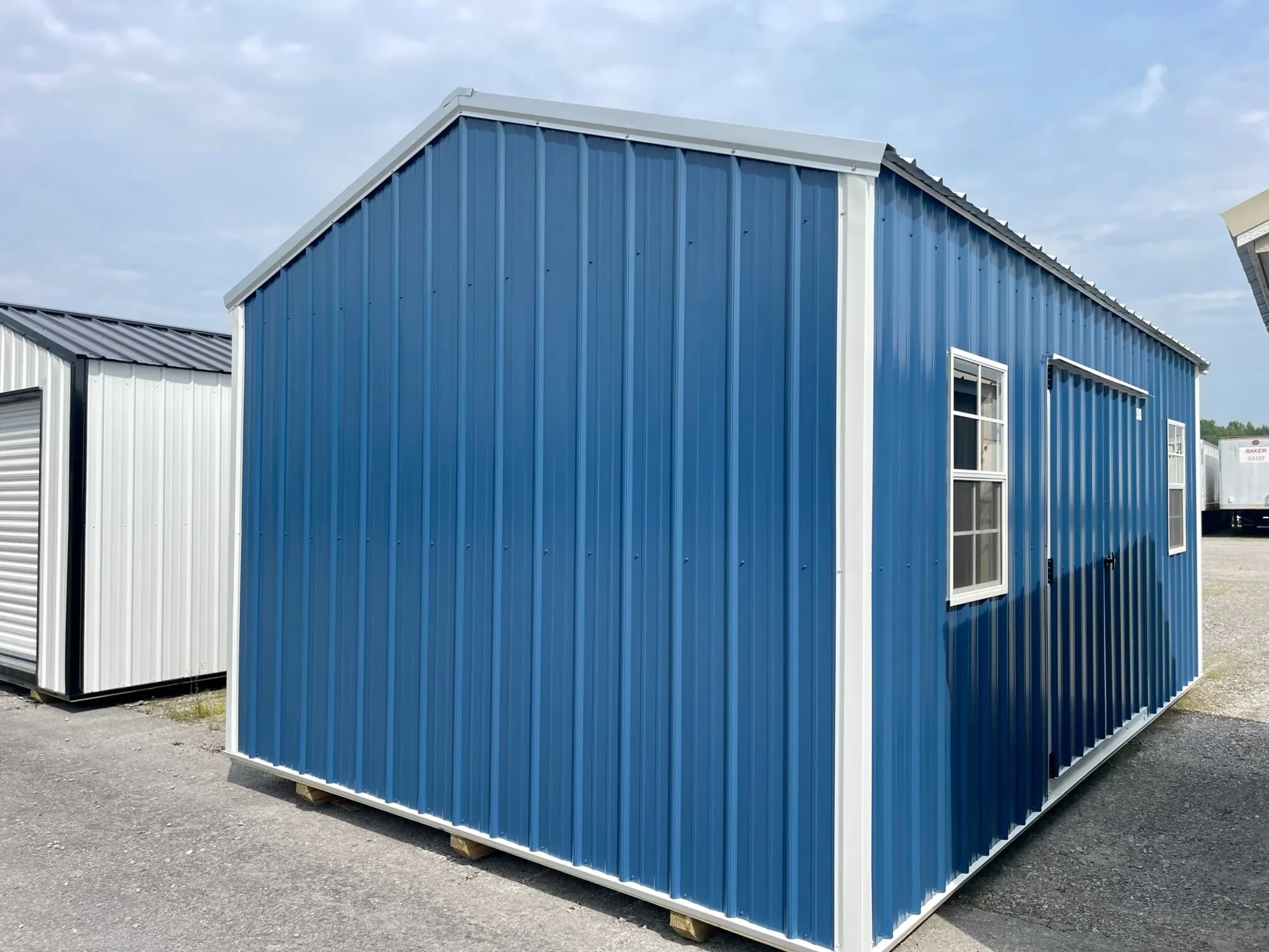 a blue metal garden shed with two windows and double doors