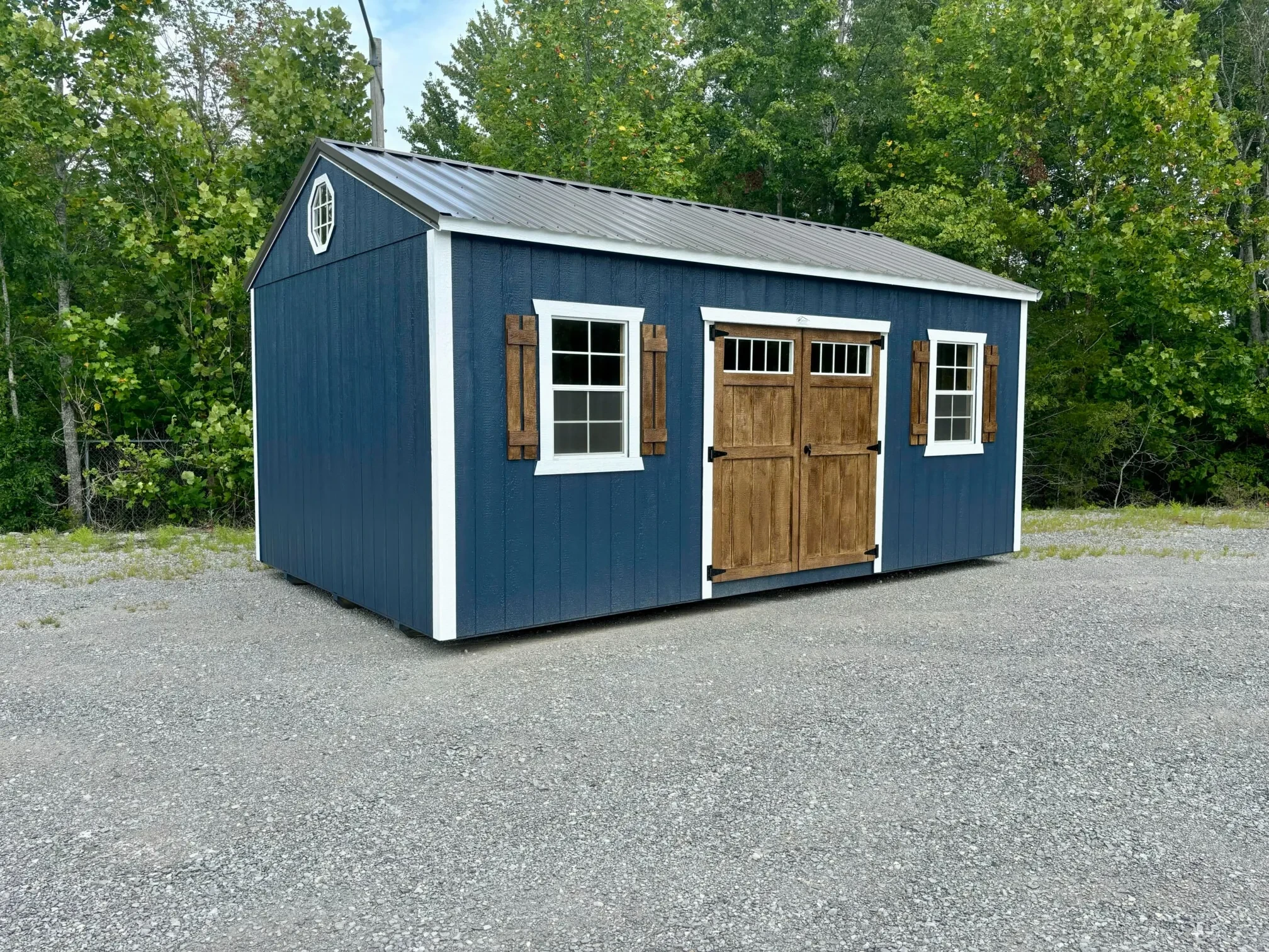 a blue garden shed with stained doors and shutters
