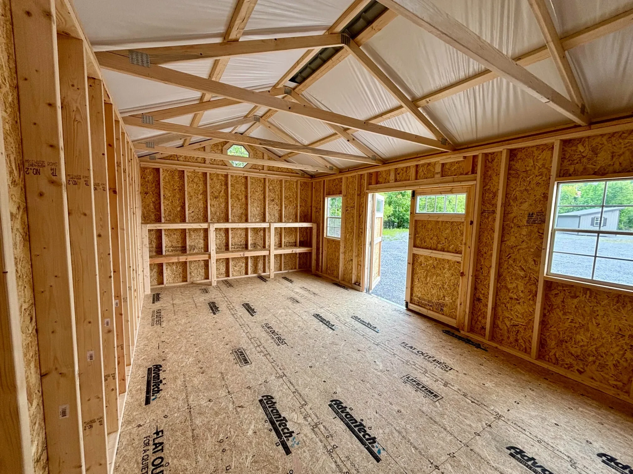inside a wood garden shed looking at the double doors and the double shelves