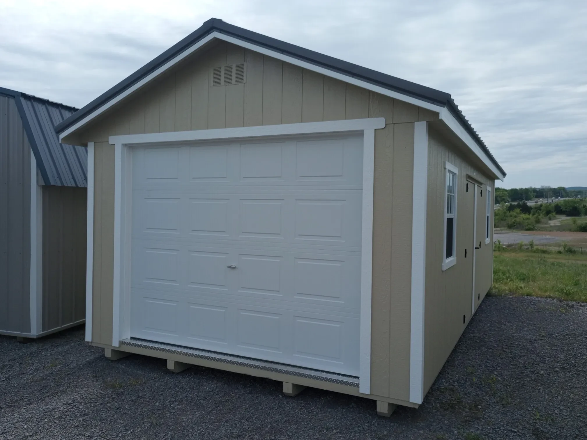 a stone colored garage garden shed with an overhead garage door, double doors, and two windows