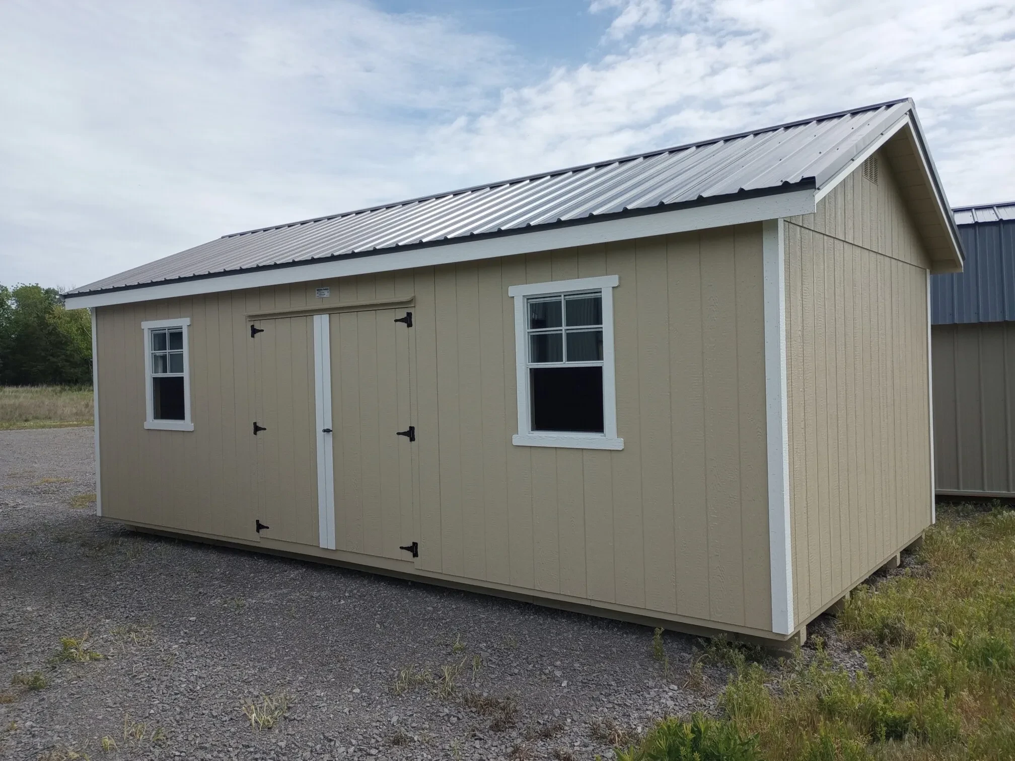 two windows and double doors on the side of a garden shed garage