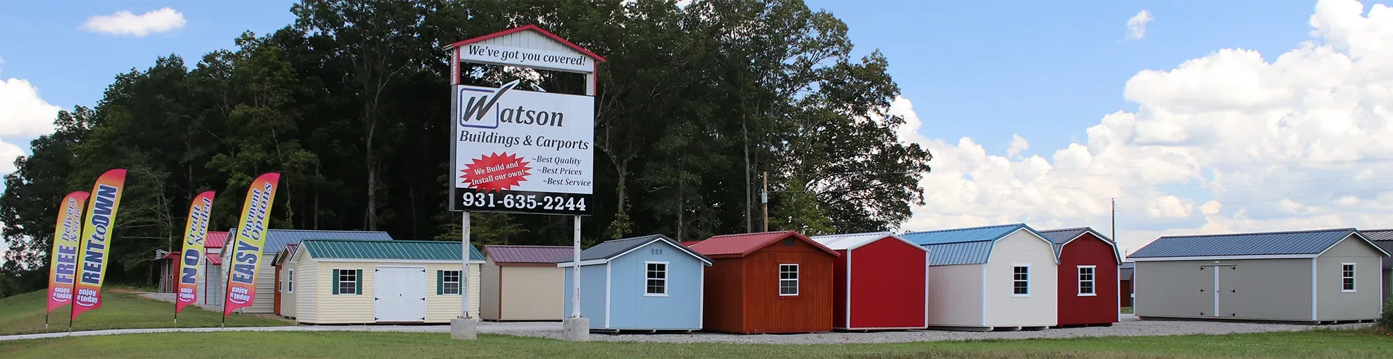 many colorful sheds and banner flags on the morrison lot as seen from the road