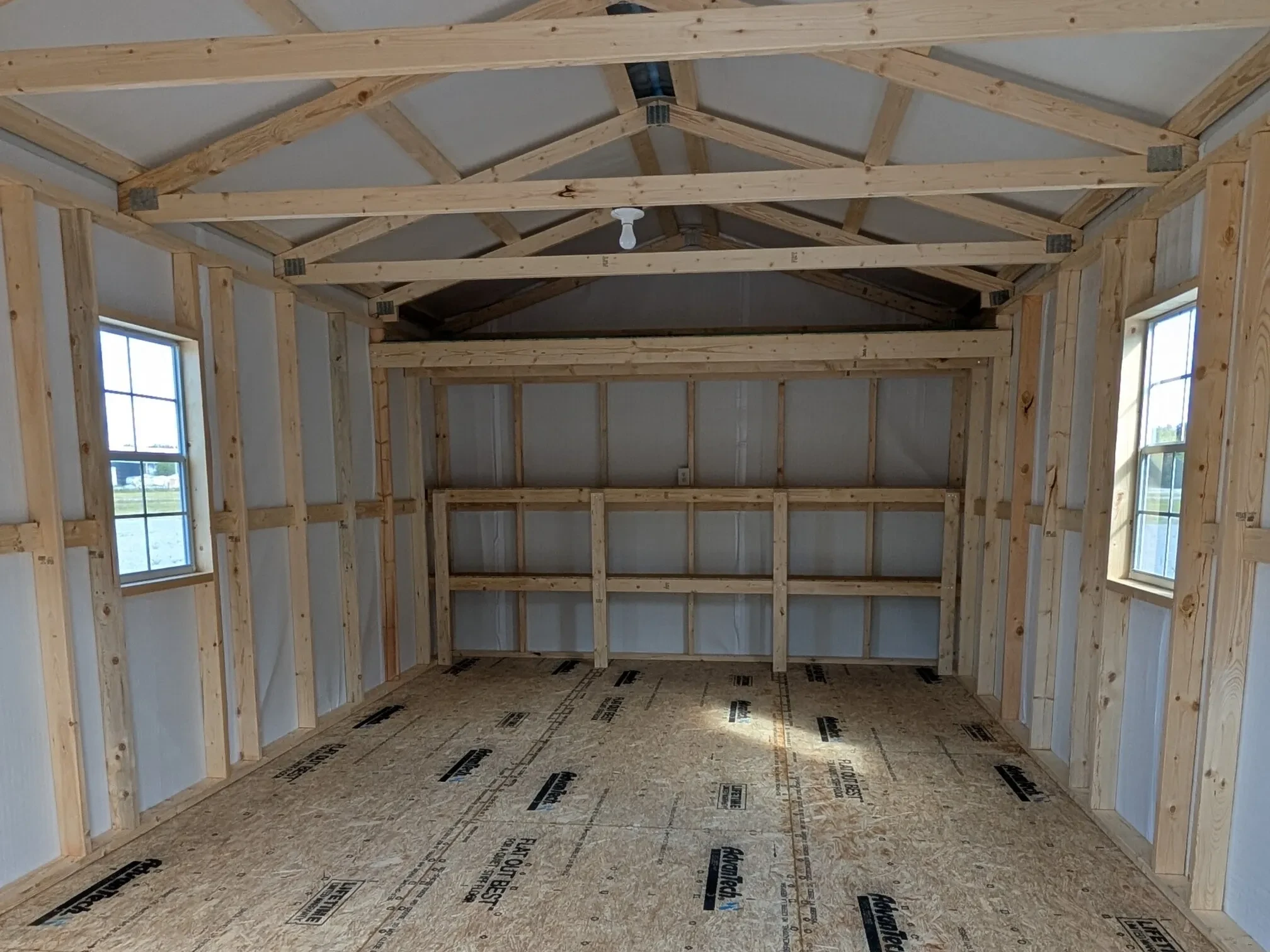 inside a large metal shed with double shelves and windows on each wall