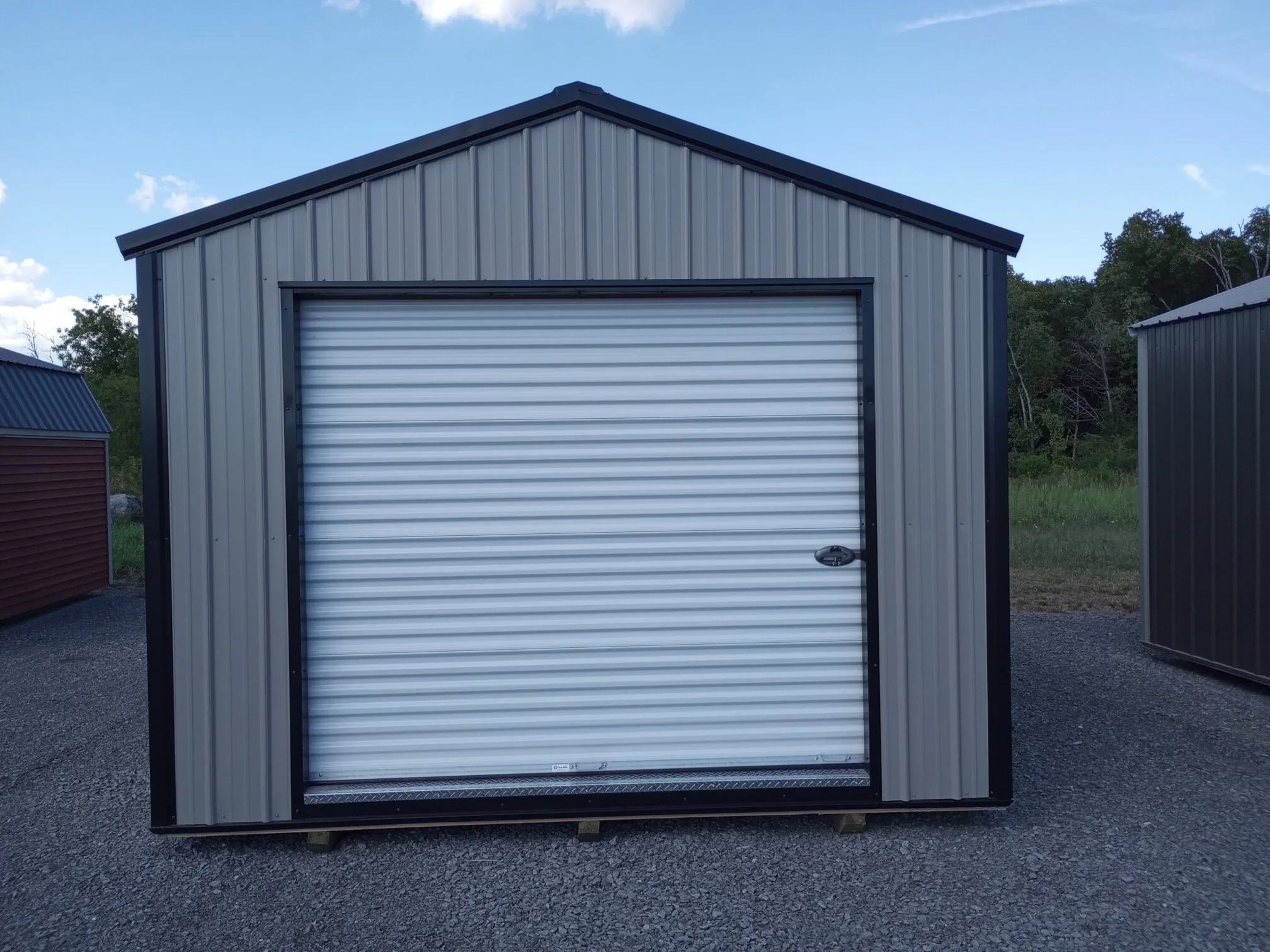the front of a metal garage shed showing the 8x7 rollup door
