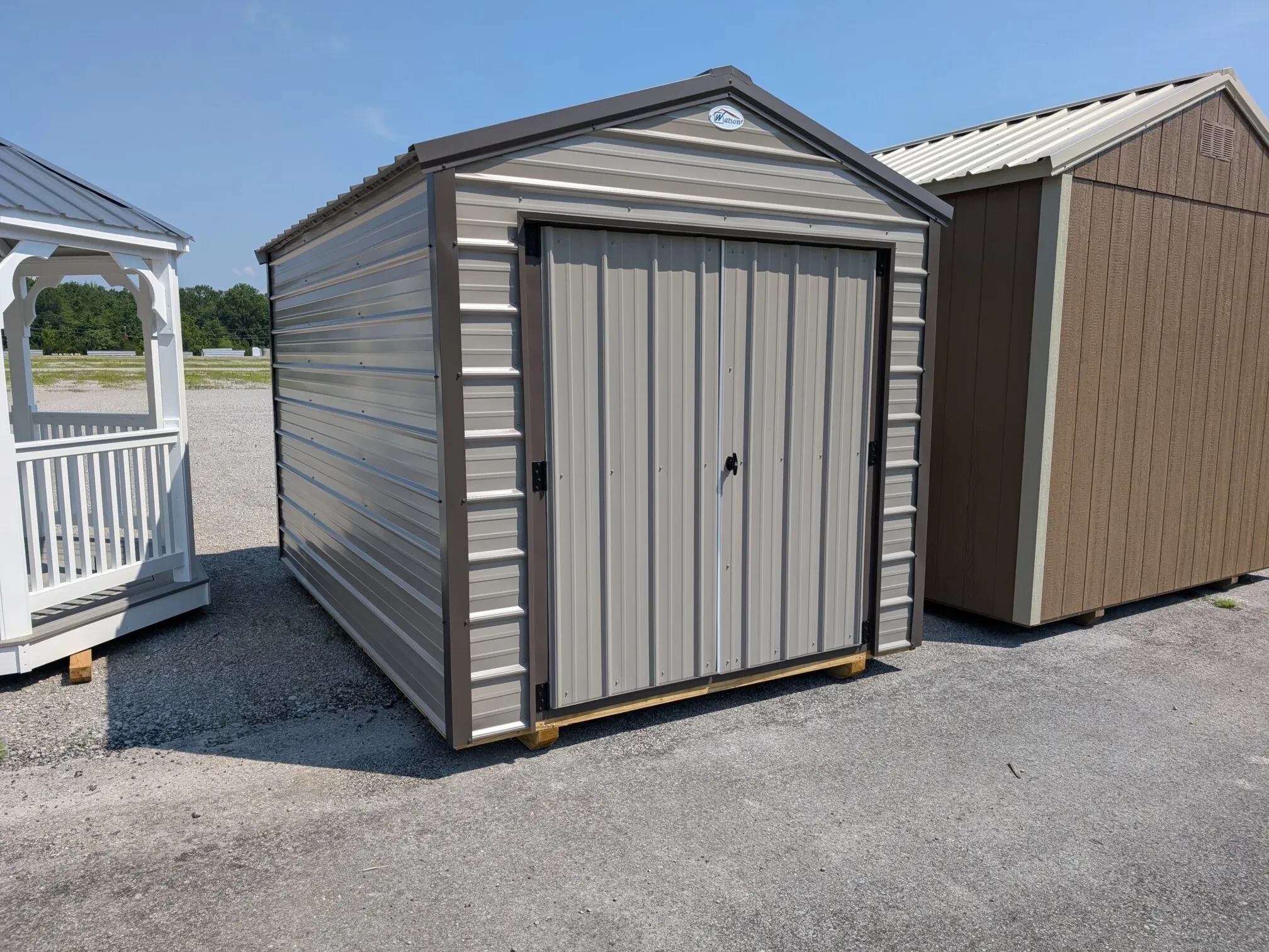 a clay colored metal shed with bronze colored trim and double doors