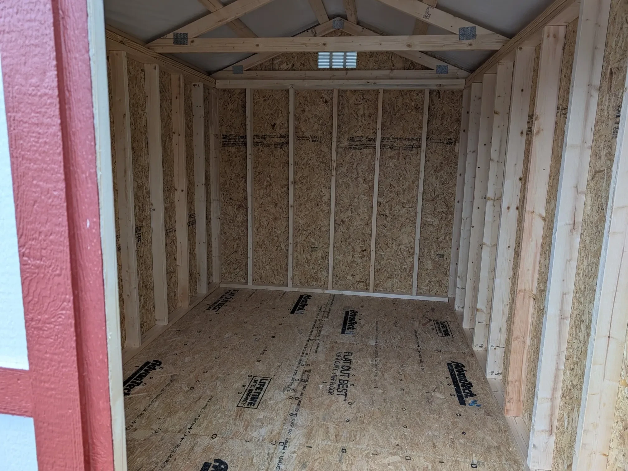 looking through an open door into a small white shed
