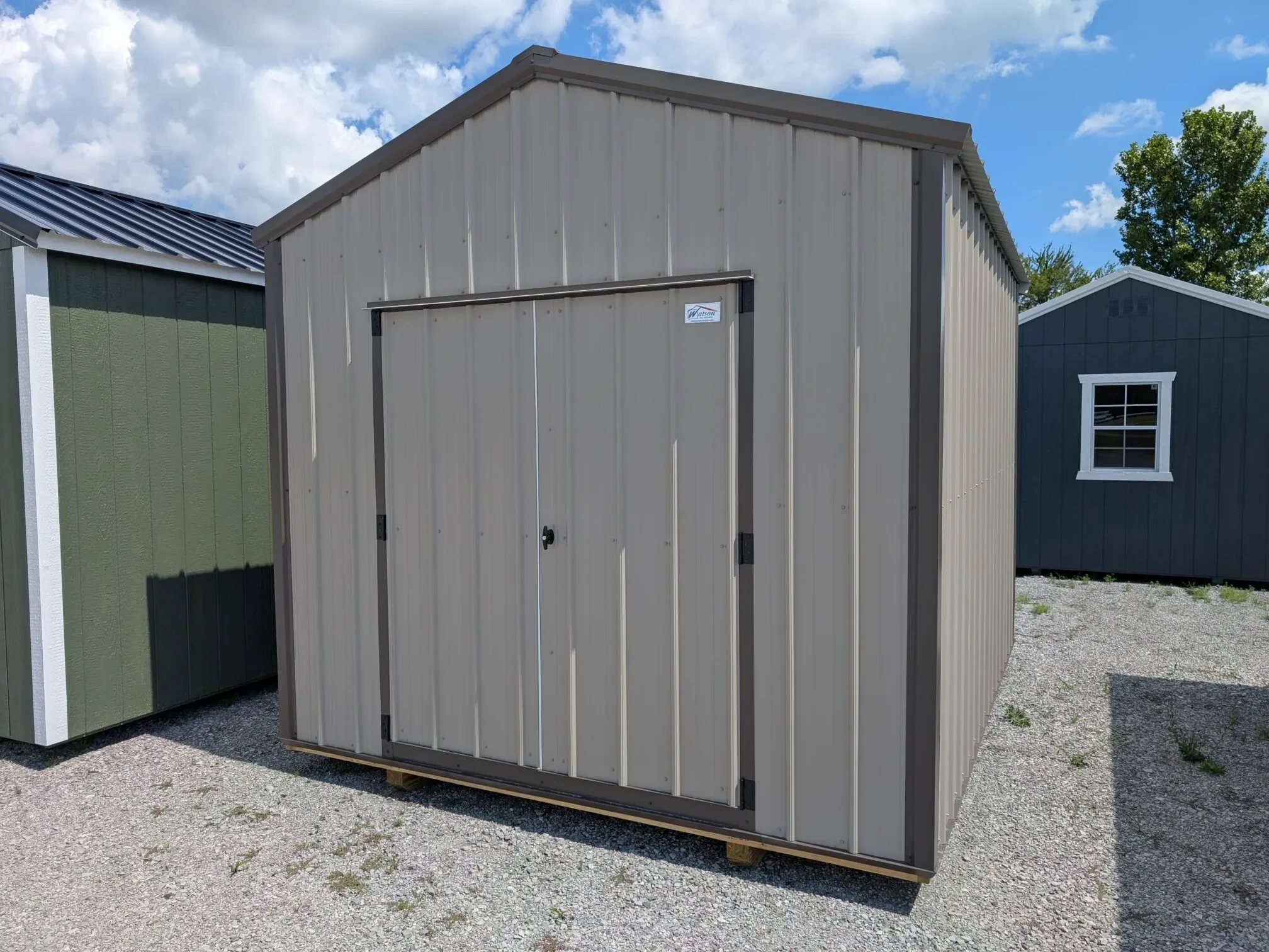 a clay colored metal utility shed with double doors