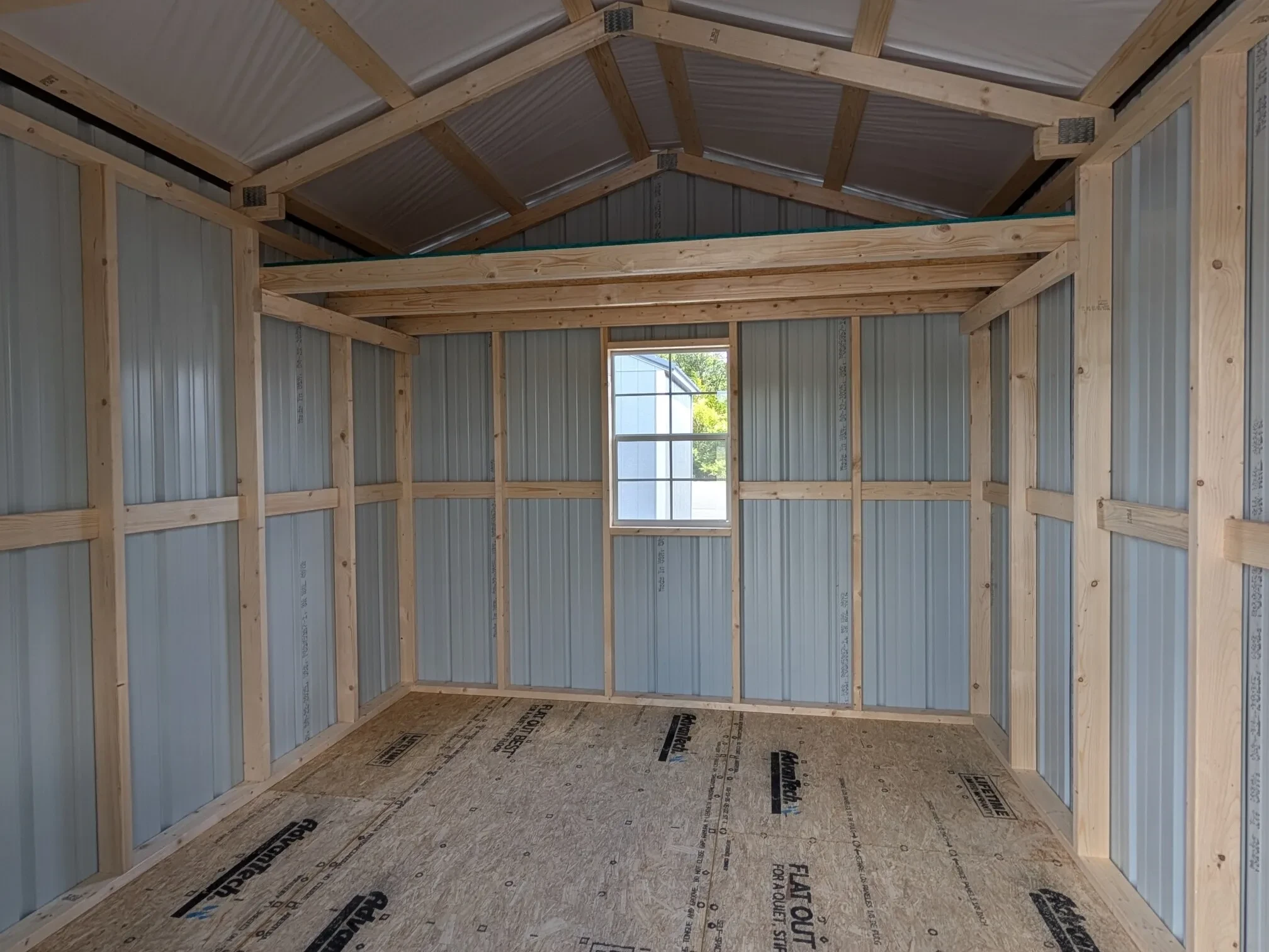 inside a metal utility shed showing a loft and a 2x3 window on the back wall