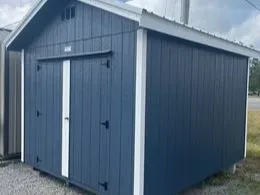 a blue wood utility shed with double doors and a roof overhang