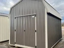 a bronze colored metal lofted barn with double doors