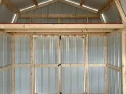 a loft above the double doors inside a brown metal lofted barn
