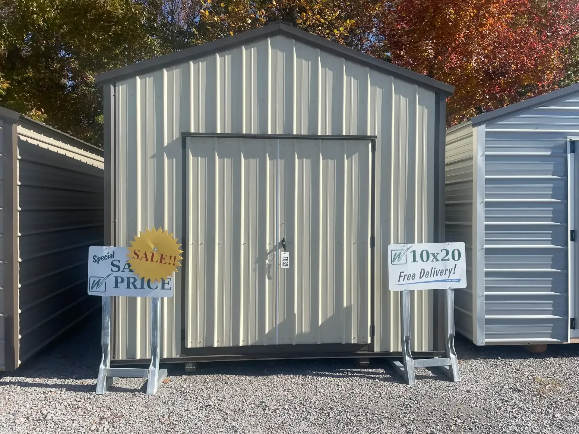 a stone colored metal utility shed with double doors