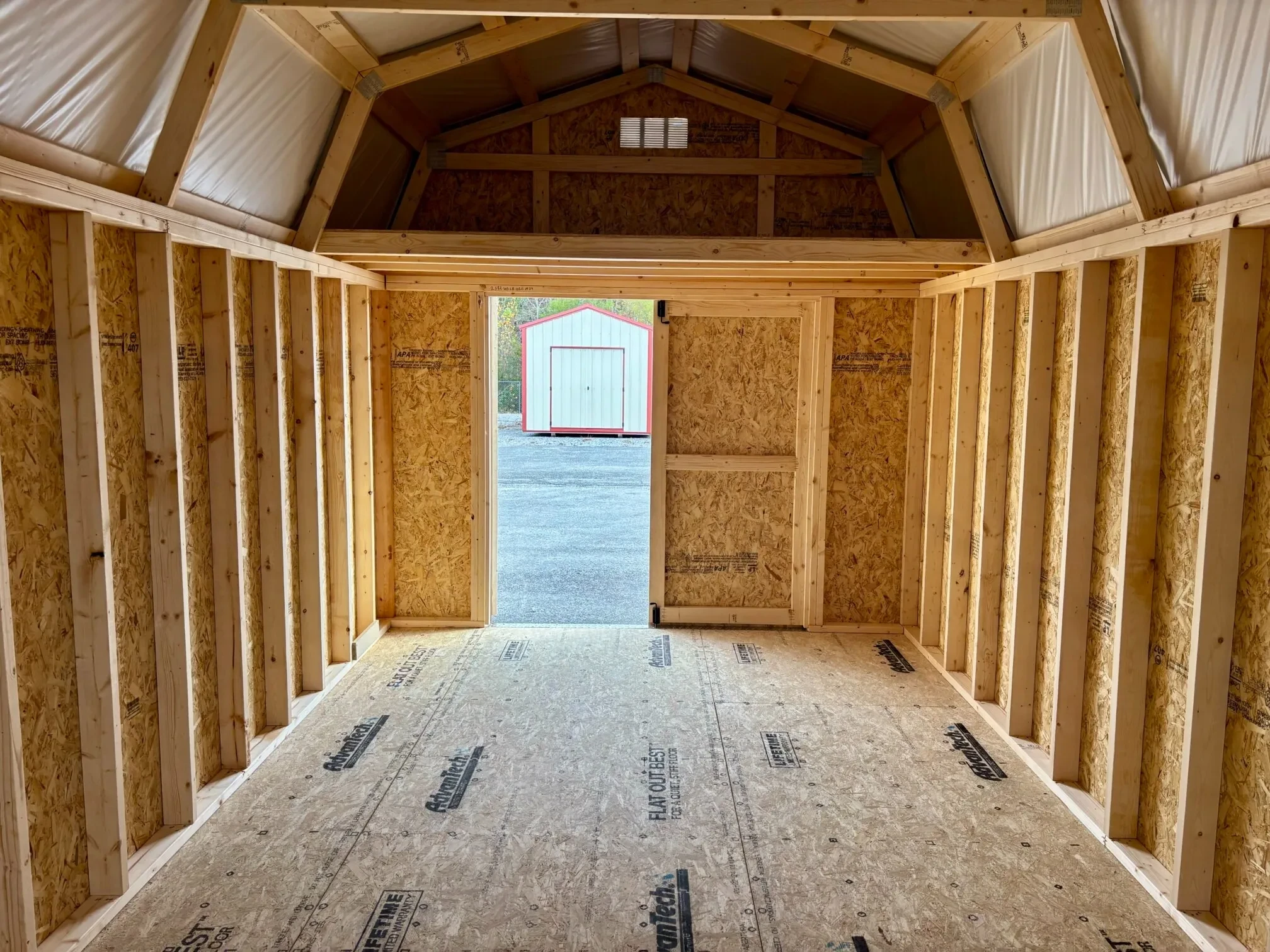 72" double doors open under a loft from inside a wood lofted barn