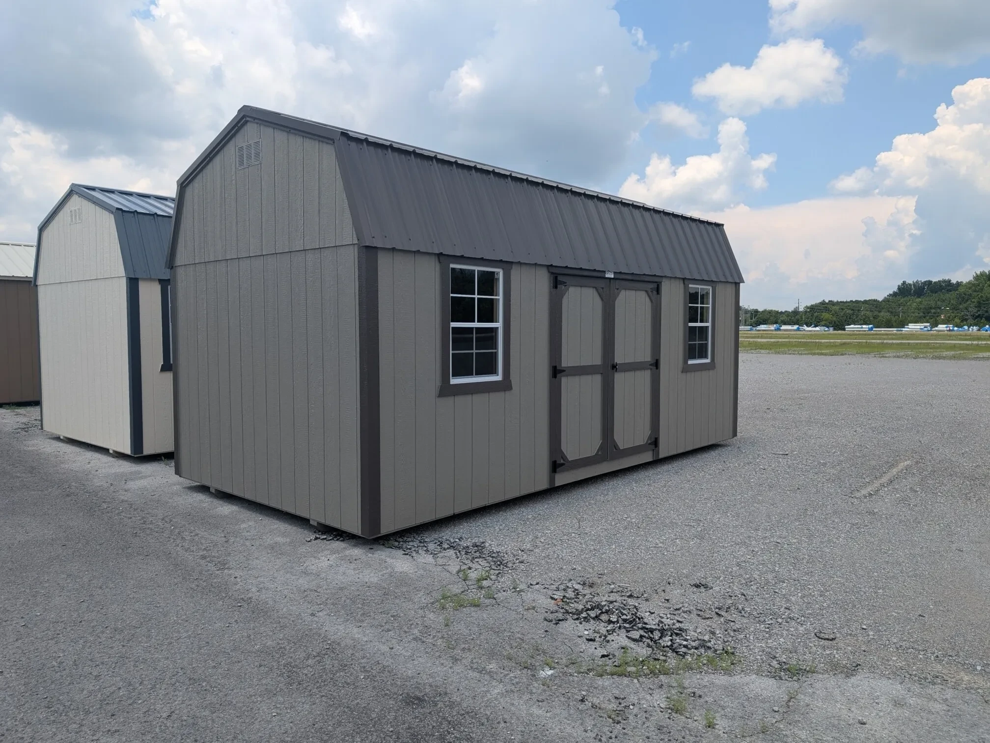 a clay colored side lofted barn with double doors and a 2x3 window on each side of the double doors