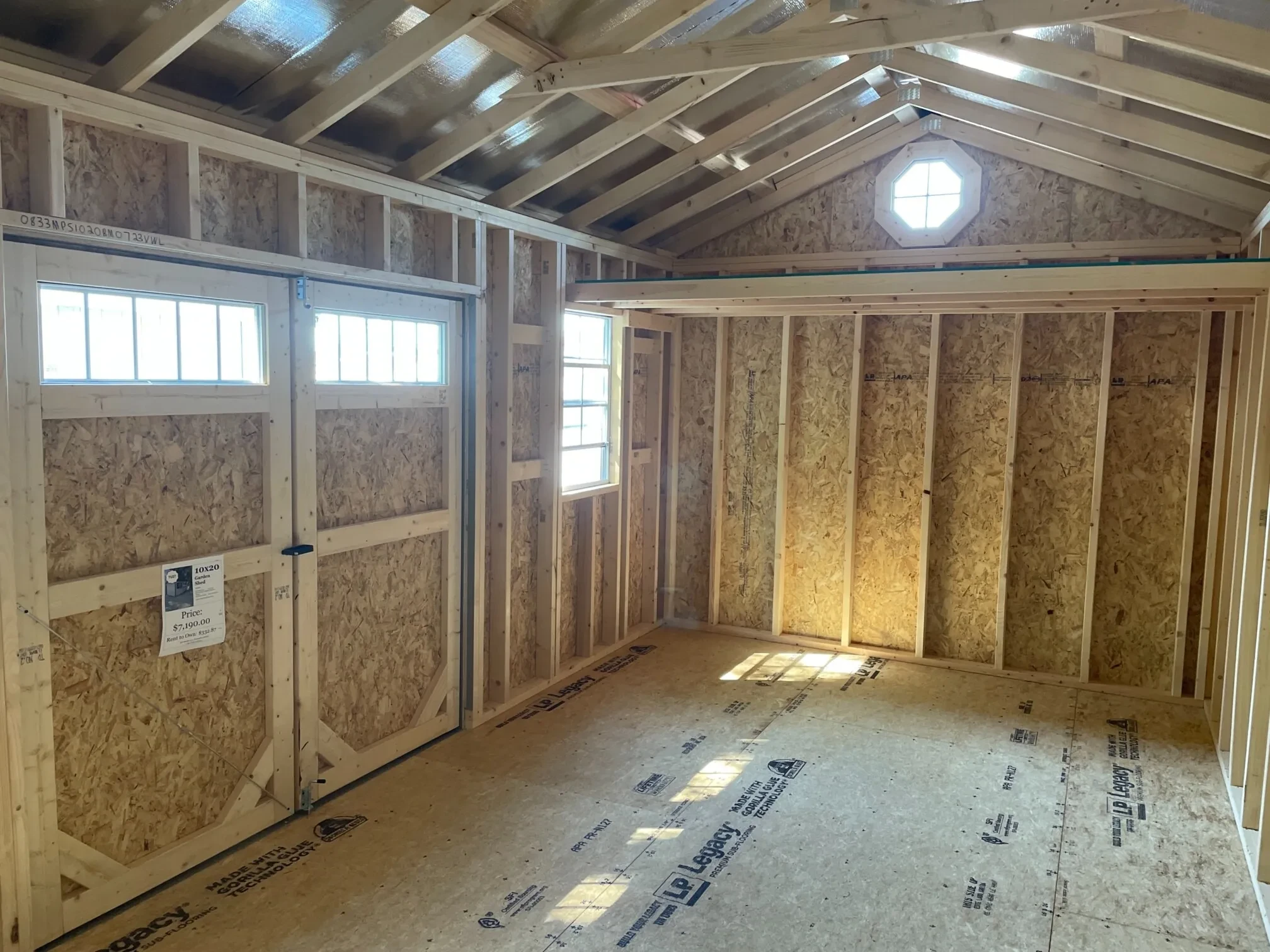 inside a wood garden shed with a lot of sunlight coming in from the 2x3 windows, transom windows, and octagon windows