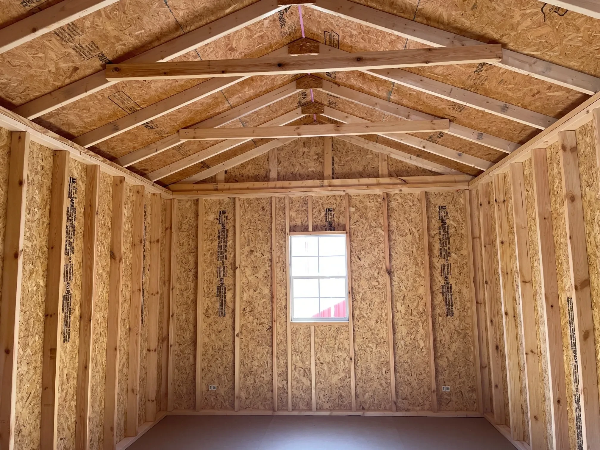 a window along the back wall from inside a wood utility shed