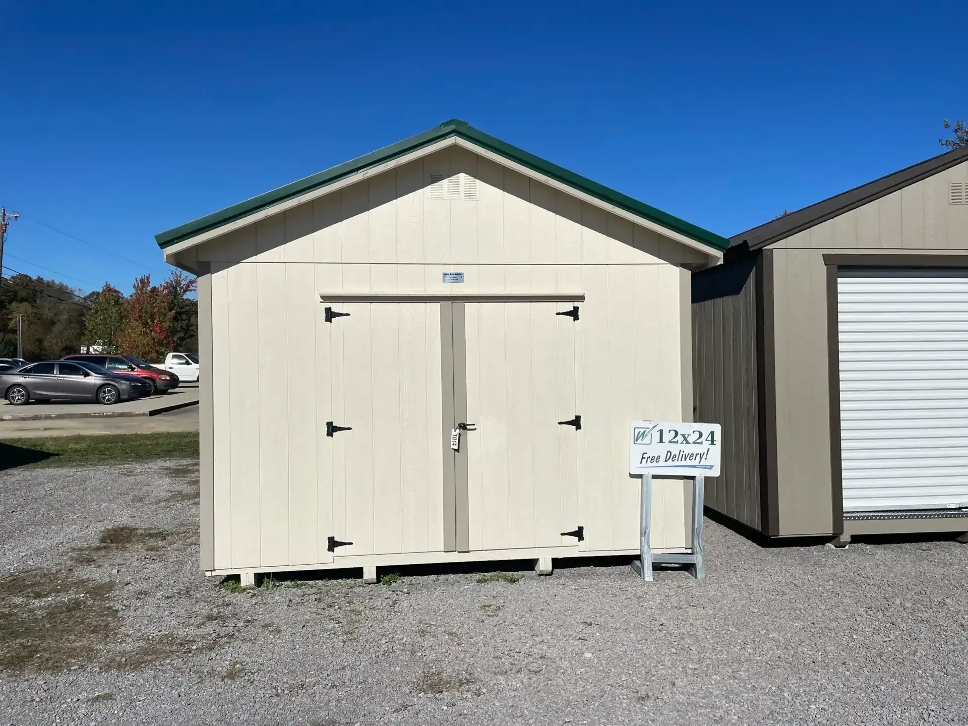 the front of a navajo white colored wood shed with double doors