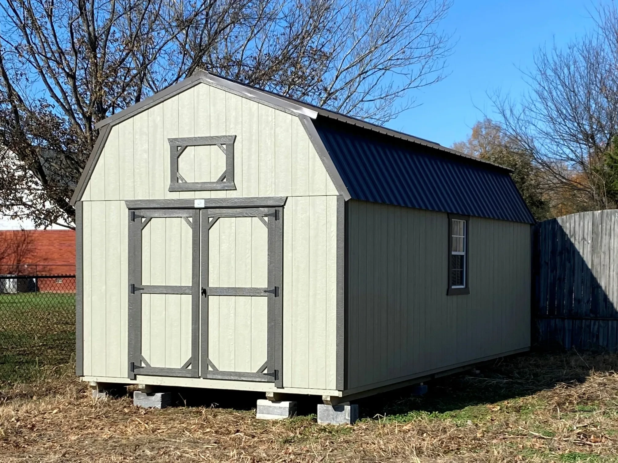 a long lofted shed with double doors in the front and a window in the side