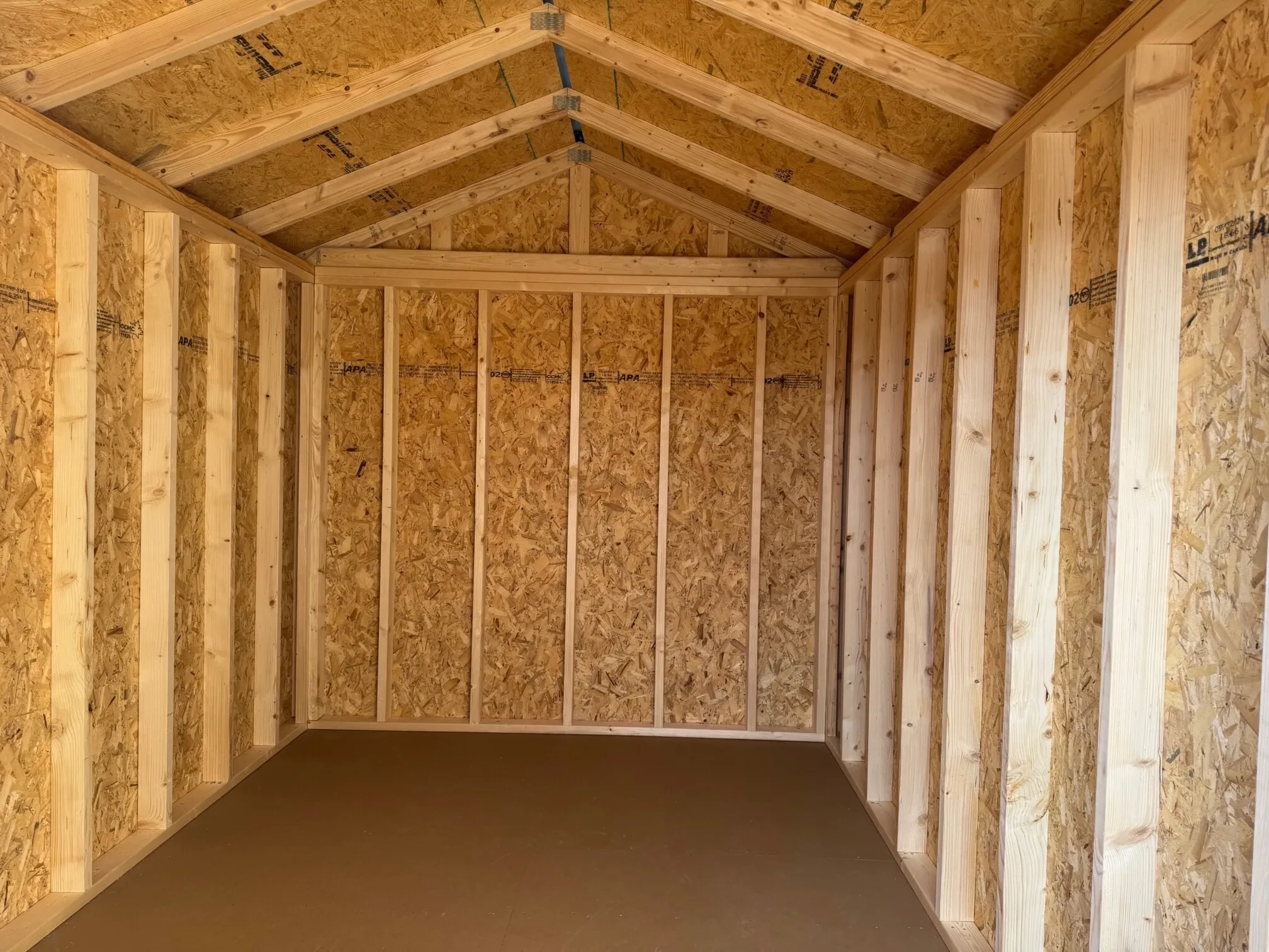 the interior of a wood utility shed with nothing in it