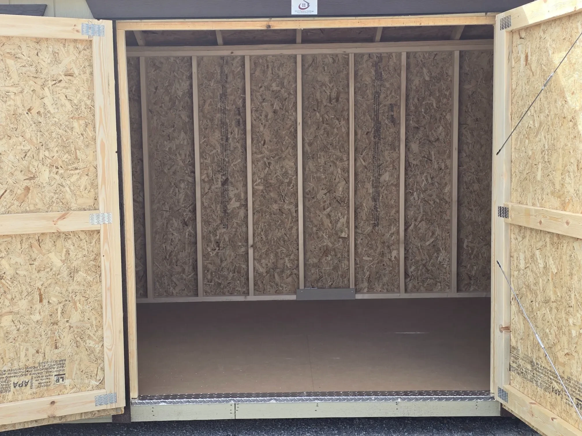 double doors on a beige garden shed that are wide open looking inside