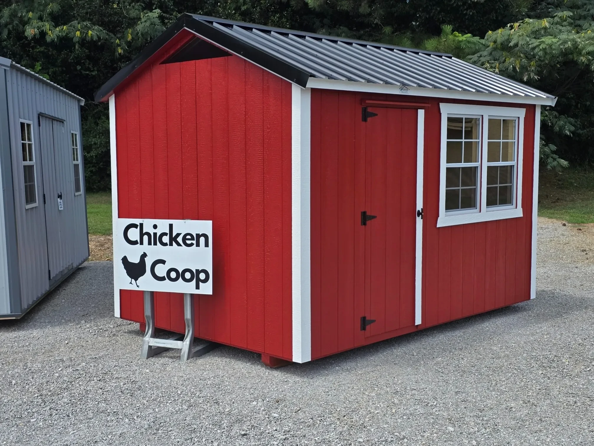a red chicken coop with two doors side by side and a walk in door, all painted red
