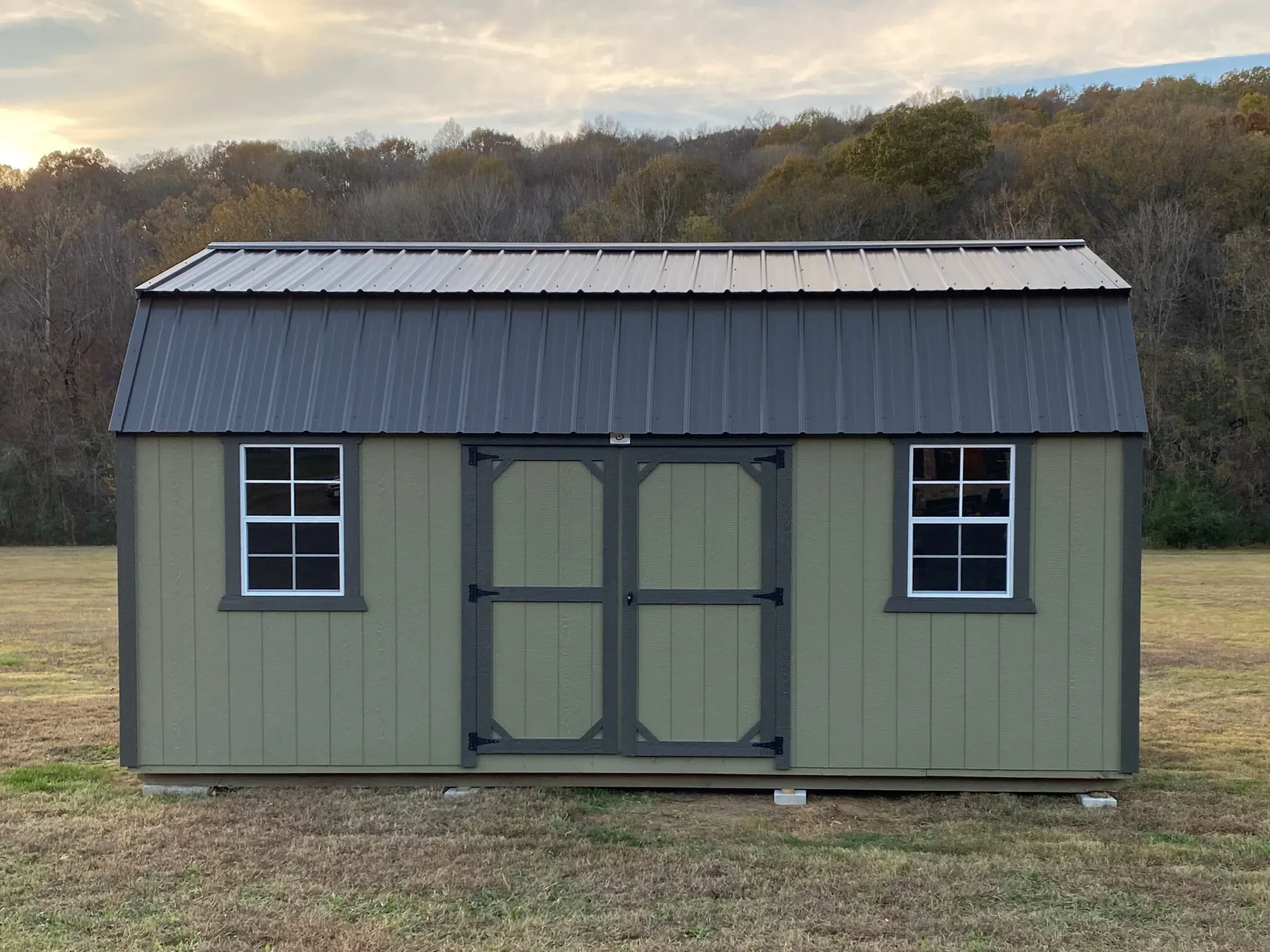 a side lofted shed with double doors centered in the side and a window on each side of the doors