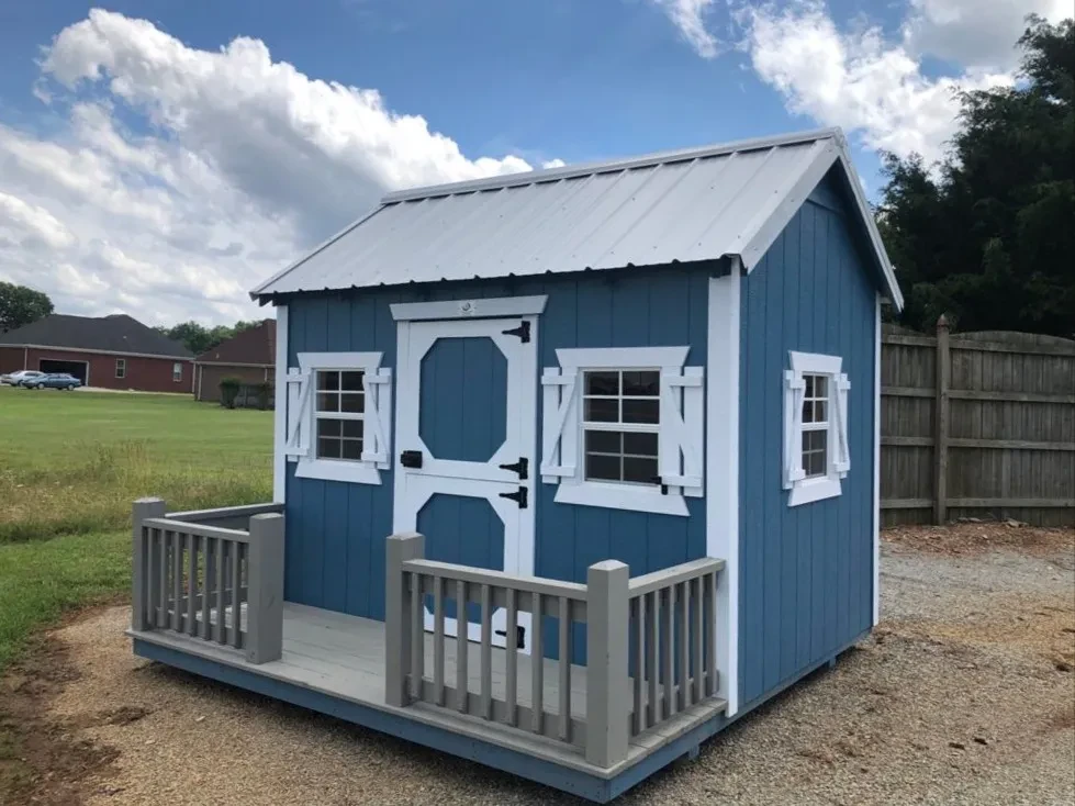 a cute little blue playhouse with white trim with a small porch and windows