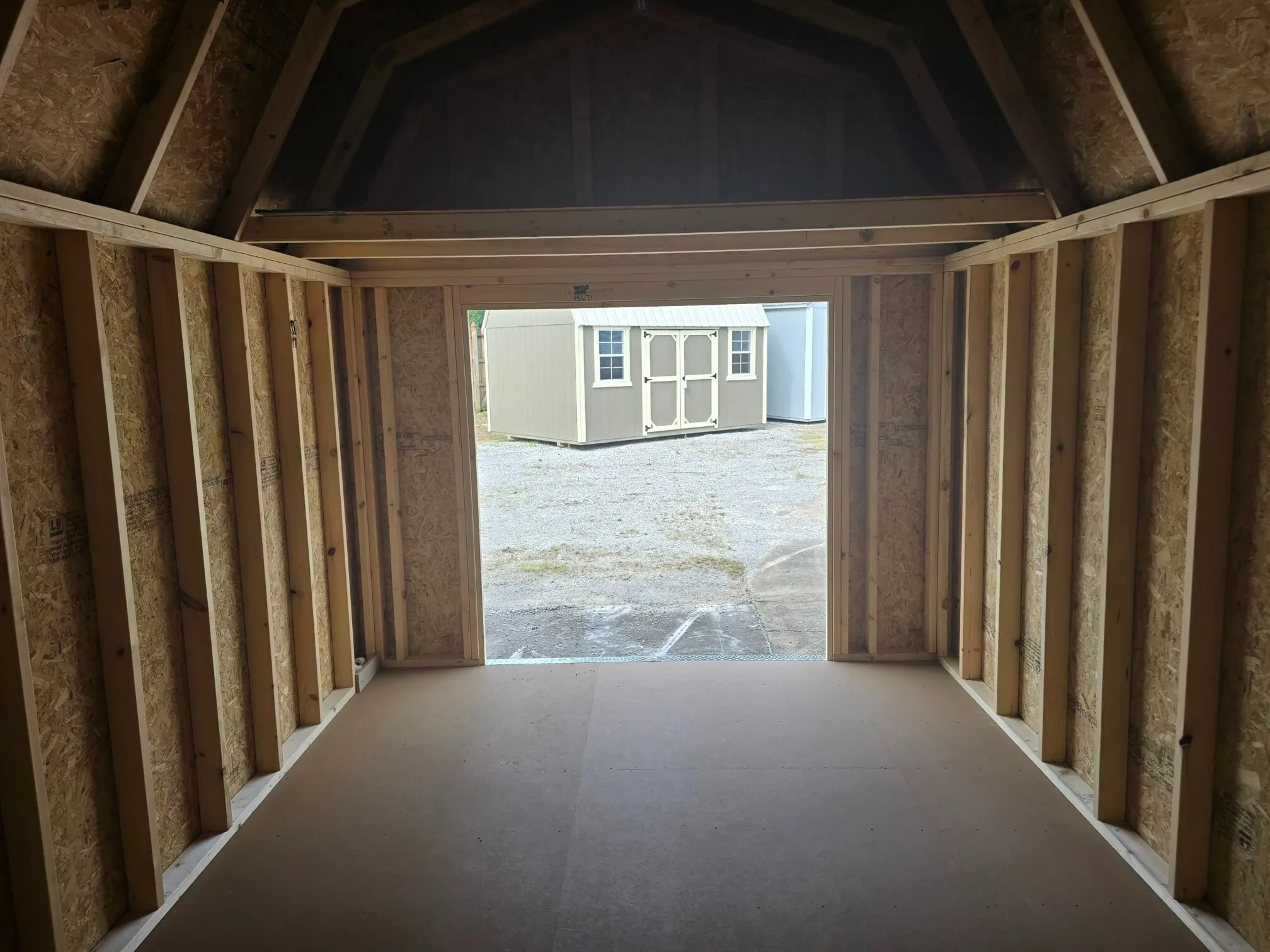 looking through open double doors from inside a wood lofted barn