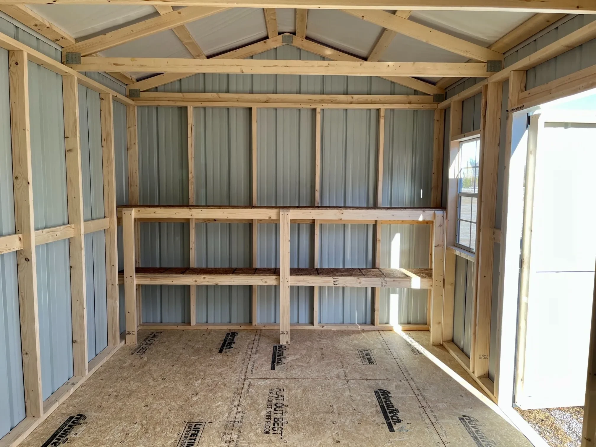 double shelves along the side wall inside a metal garden shed