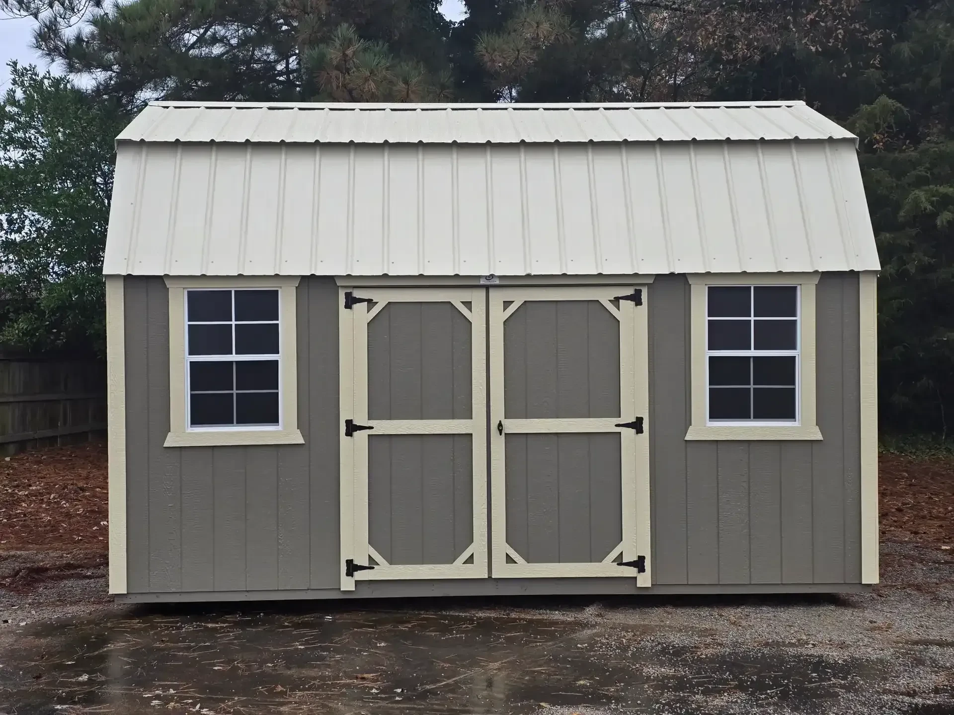 a shale colored side lofted barn with a light stone colored metal roof, two windows and double doors