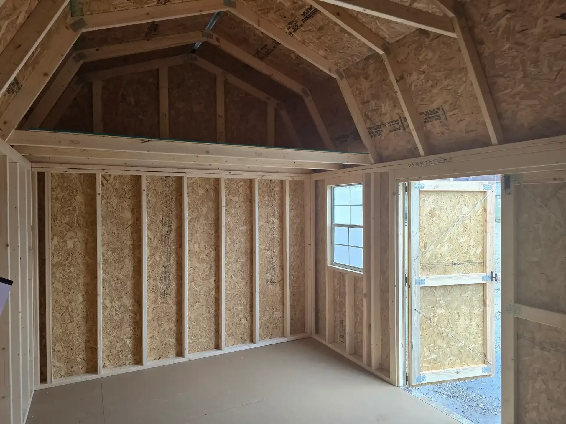 a loft inside a lofted barn with a window and a door open