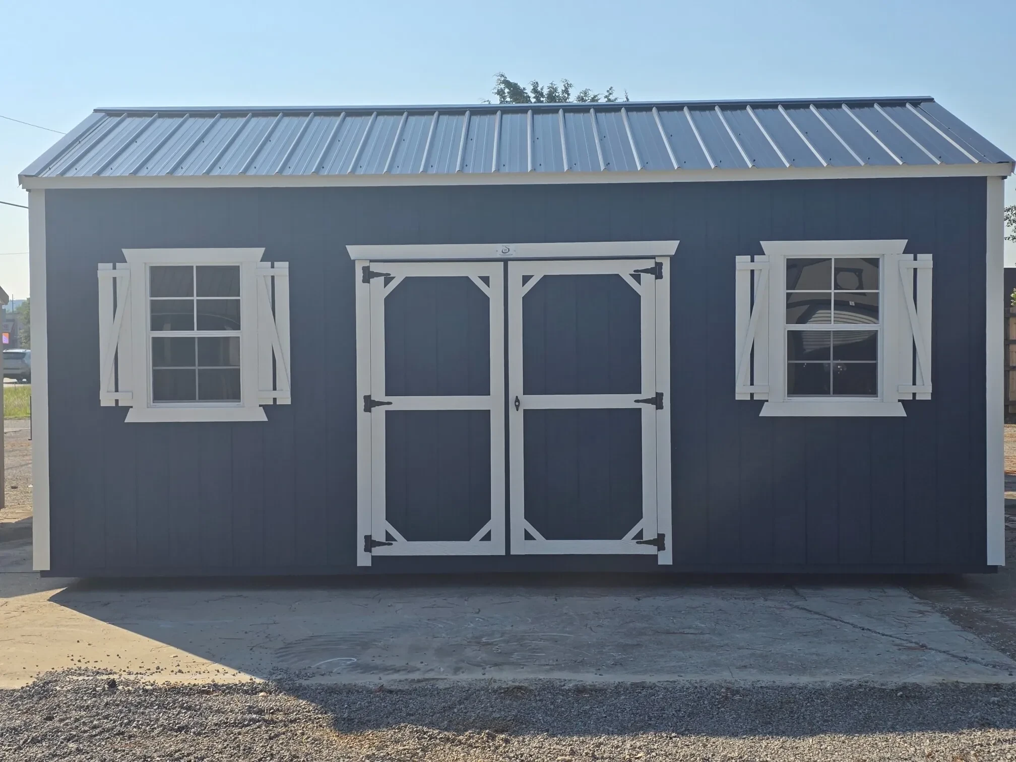 a blue garden shed with double doors and windows with white shutters