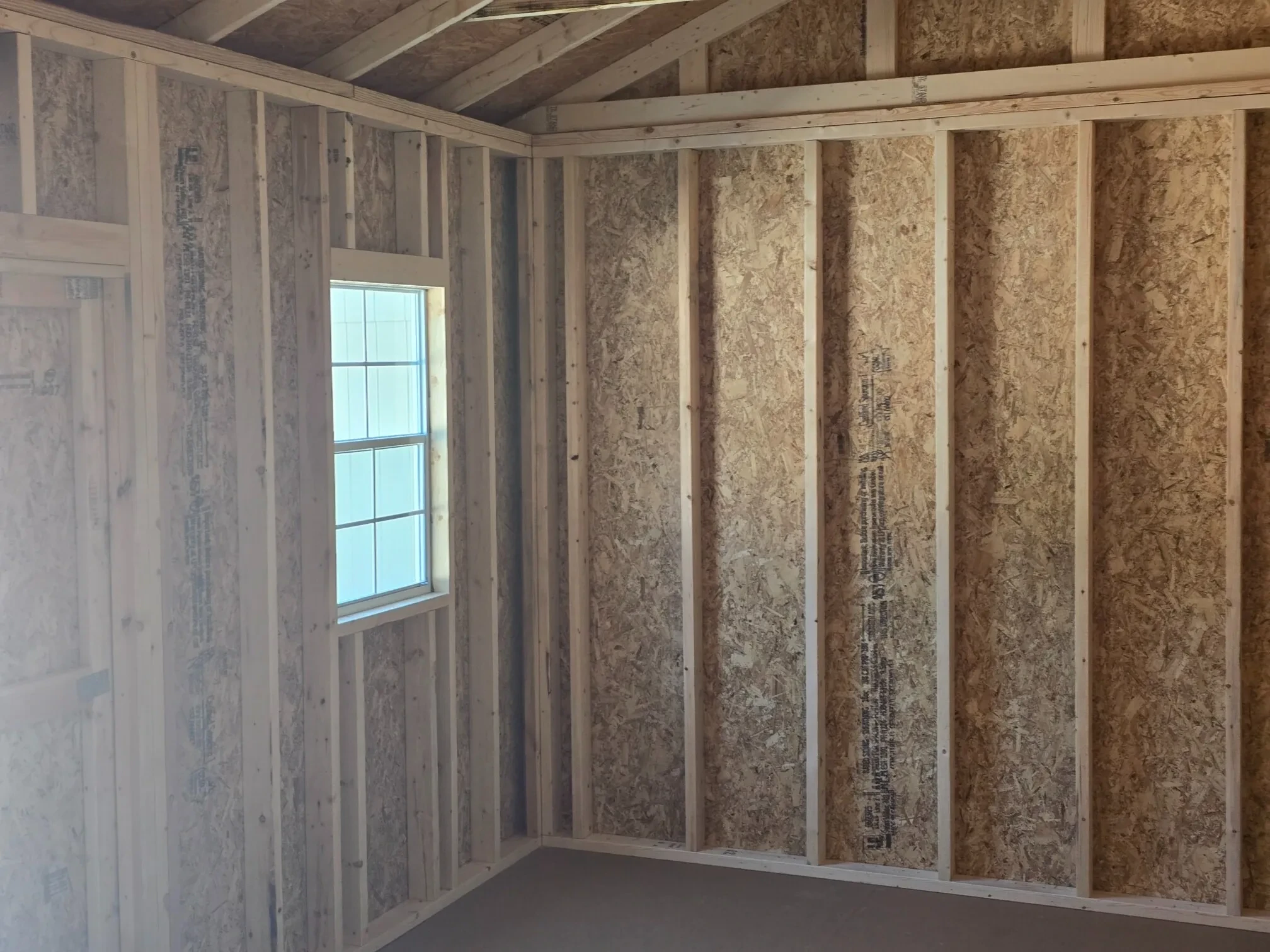 inside a wood garden shed with a window that is closed