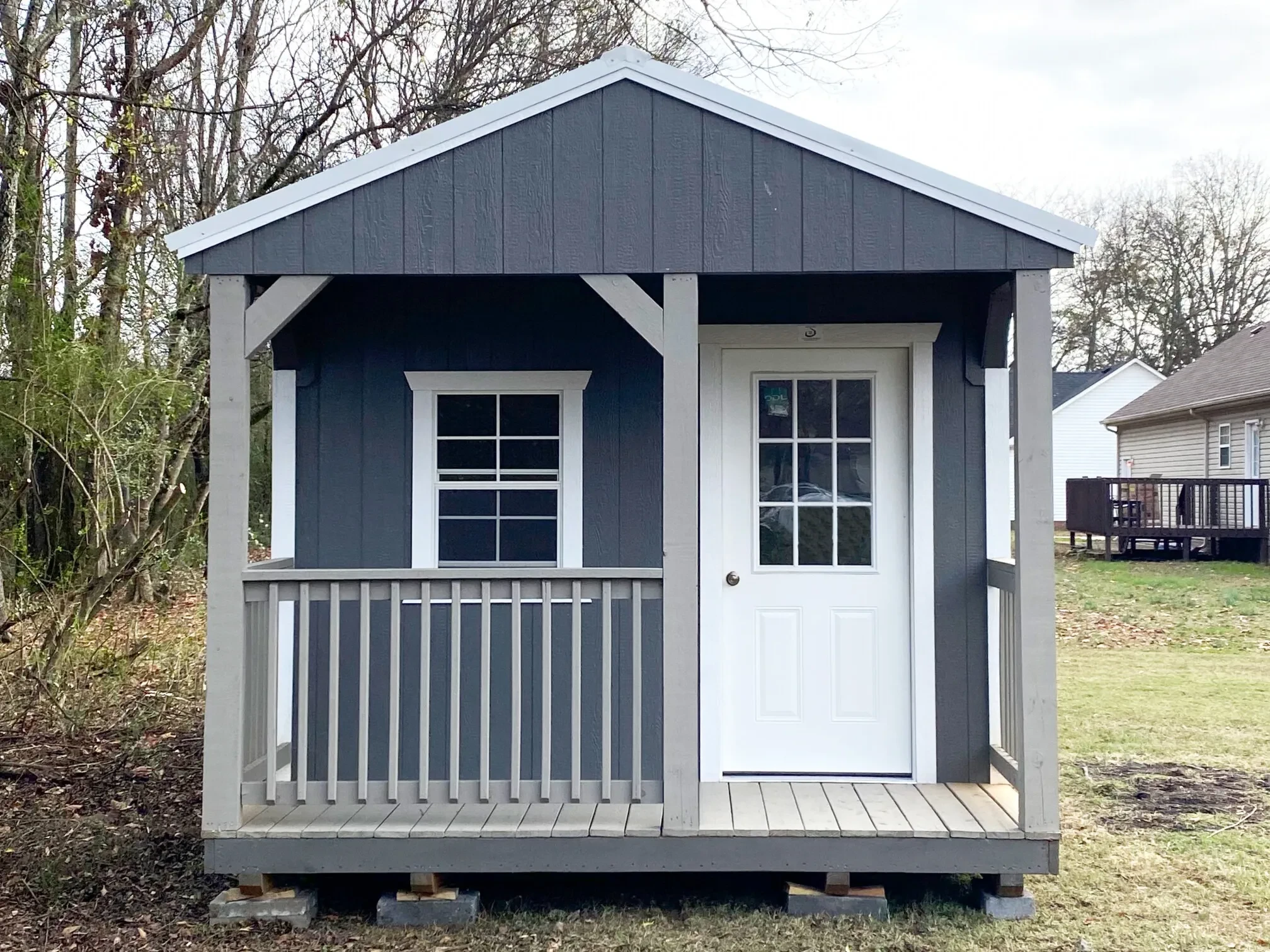 a cabin shed with a 4' porch on the front of the shed and there is a walk-in door and window off the porch